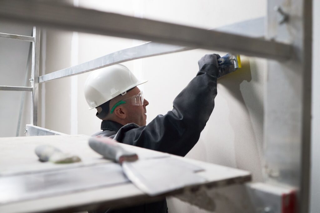 man-puttying-wall-at-construction-site-2025-06-05-23-29-10-utc
