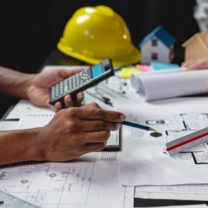 Team of engineers reviewing blueprints Sketch of a new construct Team of engineers reviewing blueprints Sketch of a new construction project with engineering tools at office desk. For improvement of house designs in mortgage, rent, sale, real estate